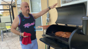 Mike Calvo grilling meat on his inaccessible Pit Boss 1150 PRO outdoor grill