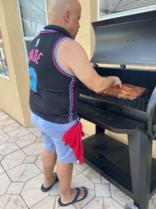 Mike Calvo grilling meat on an outdoor grill