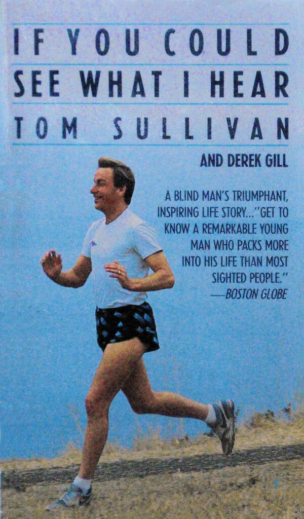 Omslag till "If You Could See What I Hear", en självbiografisk bok av Tom Sullivan, skriven tillsammans med Derek Gill. Tom springer längs stranden av en sjö med ett stort leende på läpparna.